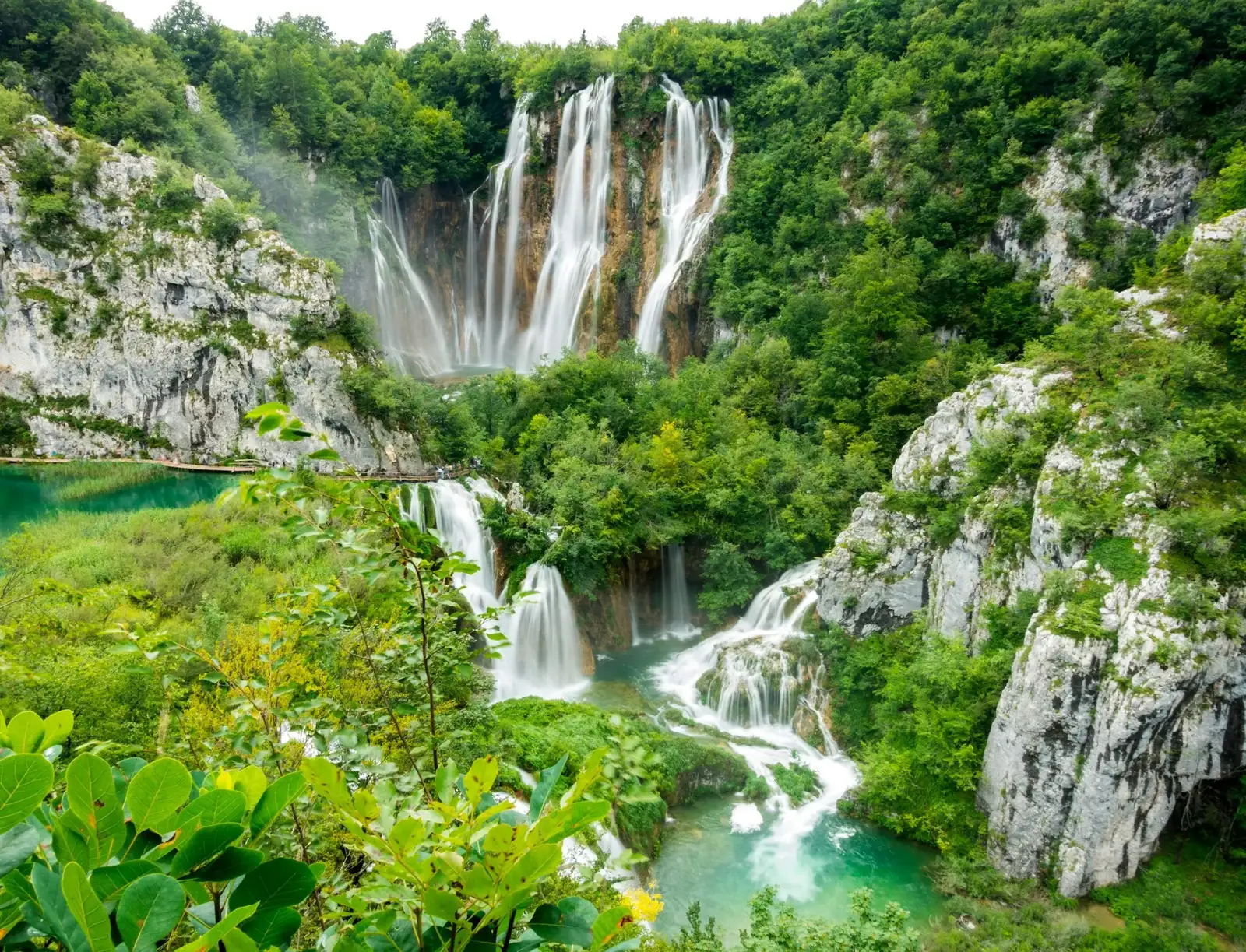 Wooden boardwalks winding across the turquoise lakes and waterfalls of Plitvice, Croatia